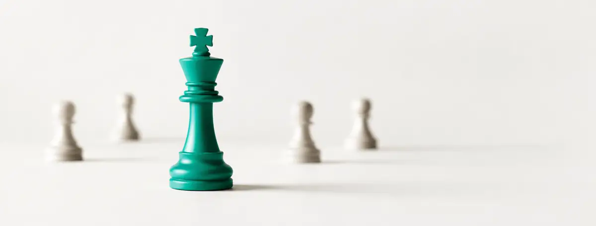 Roi d'échecs seul au premier plan, quelques pions flous en arrière-plan